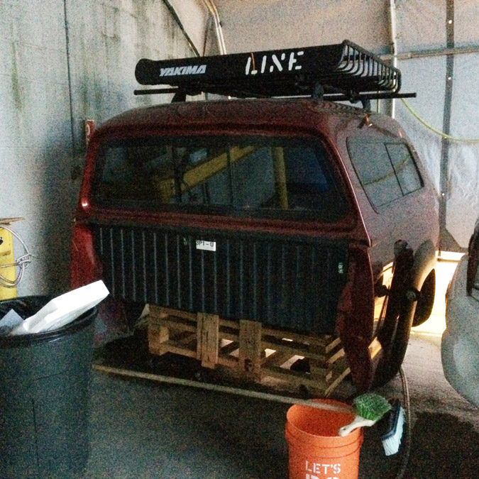 The rear truck bed of a Toyota Tacoma sits on blocks waiting for a frame replacement